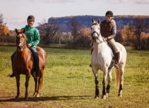 Two riders on horseback with Mount Nemo in background