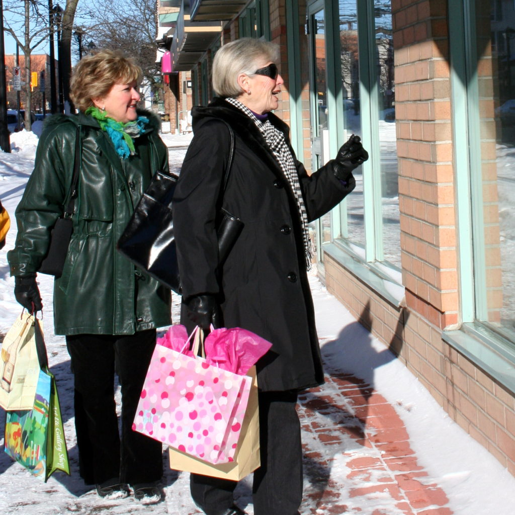 Ladies looking into windows on Brant St. downtown in winter
