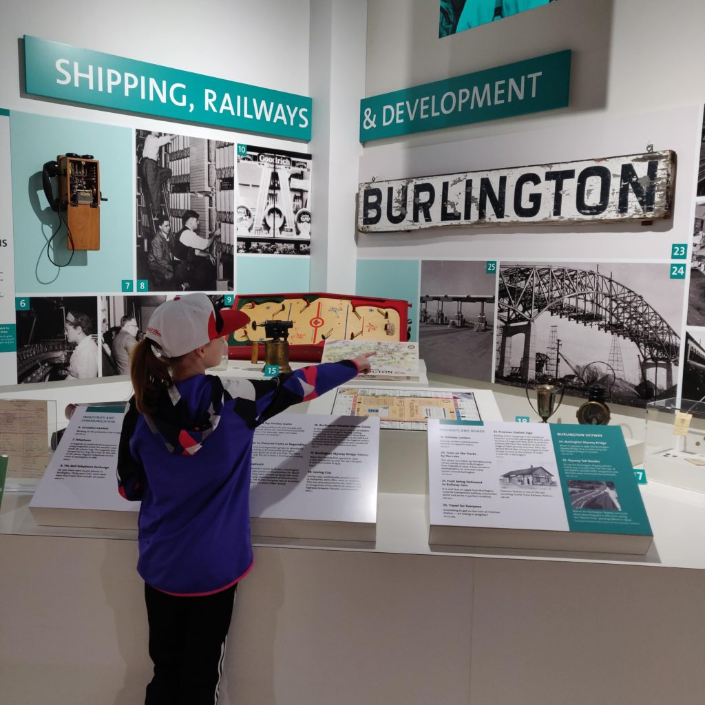 Young girl at the museum looking at a display on the history of Burlington